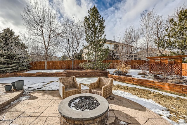 snow covered patio featuring a fire pit