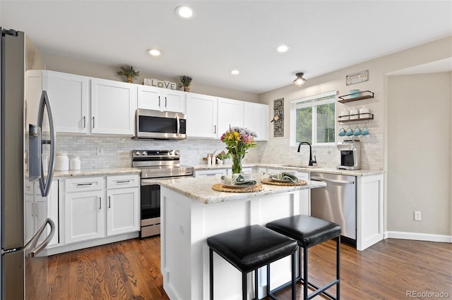 2763 Dharma Ave, Broomfield, CO 80020 - kitchen featuring appliances with stainless steel finishes, white cabinets, dark wood-style flooring, backsplash, and recessed lighting