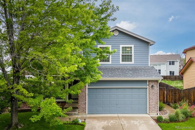 2763 Dharma Ave, Broomfield, CO 80020 - traditional home with brick siding, concrete driveway, roof with shingles, and an attached garage
