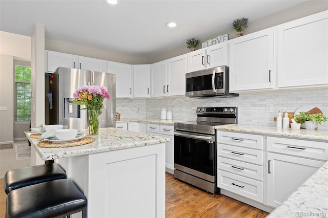 2763 Dharma Ave, Broomfield, CO 80020 - kitchen with stainless steel appliances, white cabinets, tasteful backsplash, and recessed lighting