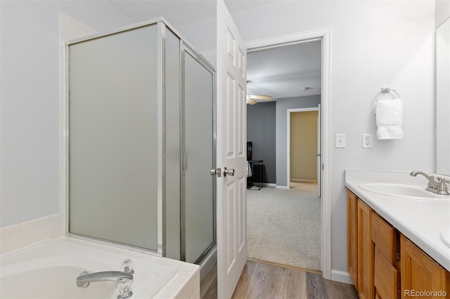 2763 Dharma Ave, Broomfield, CO 80020 - bathroom featuring a stall shower, a garden tub, double vanity, and wood finished floors