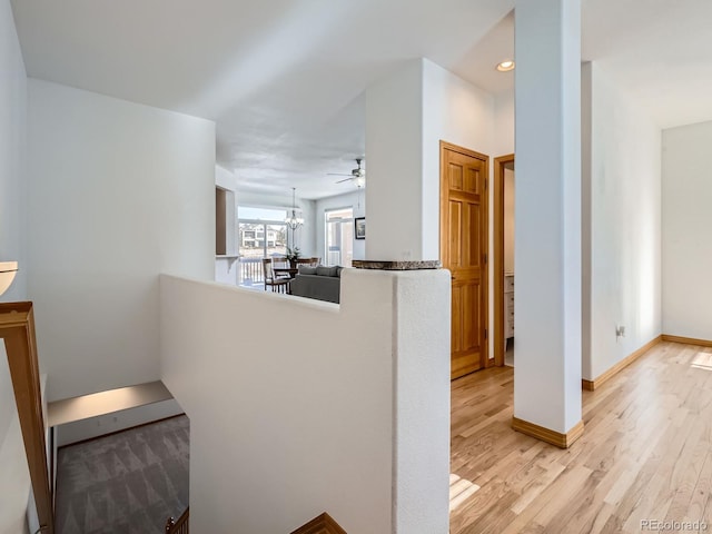 hall featuring an inviting chandelier and light wood-type flooring