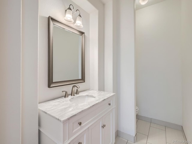 bathroom with tile patterned flooring, vanity, and toilet