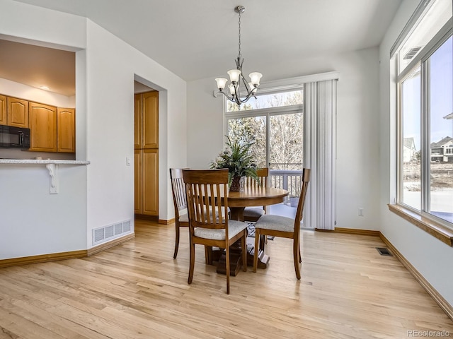 dining room with an inviting chandelier and light hardwood / wood-style flooring