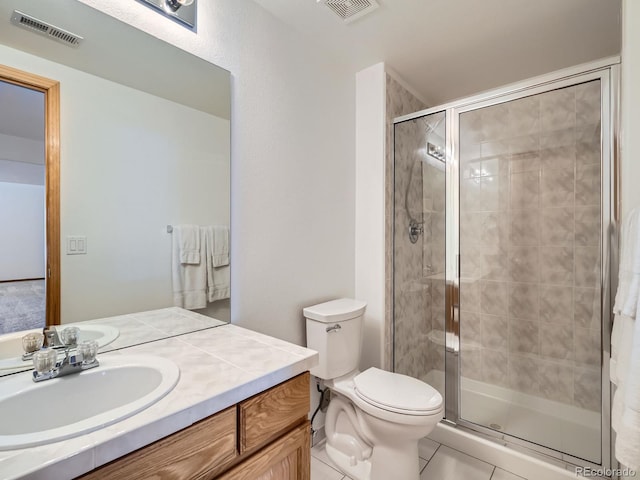 bathroom featuring an enclosed shower, vanity, tile patterned flooring, and toilet