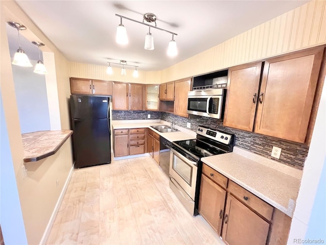 kitchen with sink, decorative light fixtures, black appliances, and decorative backsplash