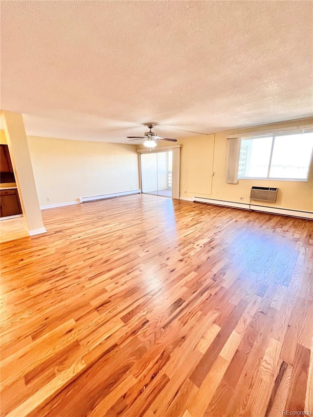 unfurnished room with ceiling fan, a baseboard radiator, light hardwood / wood-style floors, and a textured ceiling