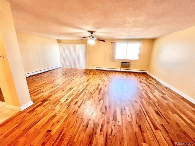 empty room featuring a baseboard heating unit, light hardwood / wood-style floors, a textured ceiling, and ceiling fan