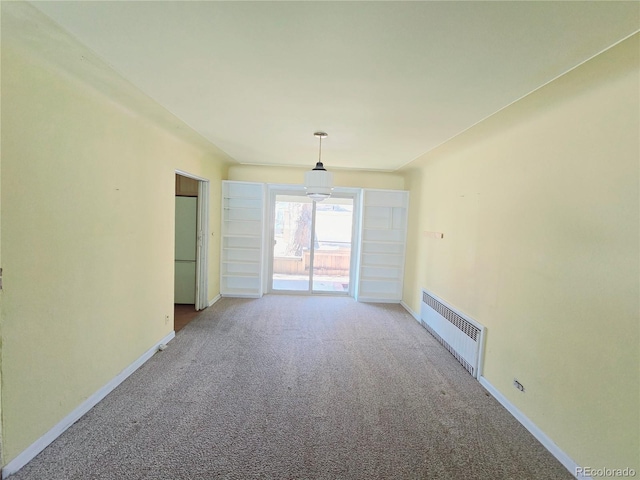 carpeted empty room featuring radiator