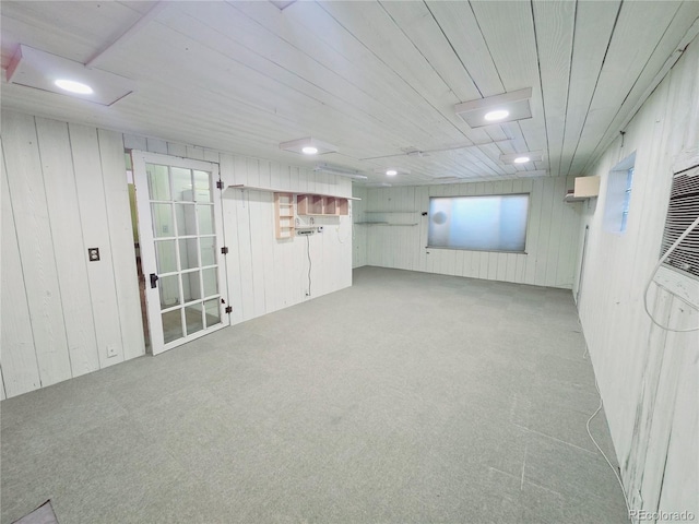 basement featuring light colored carpet and wood walls