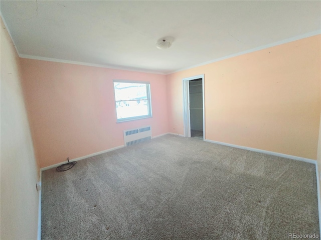 empty room featuring ornamental molding, radiator heating unit, and carpet