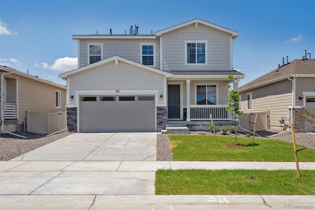 313 W Owen Ave, Keenesburg, CO 80643 - view of front of home featuring a porch, driveway, a garage, and stone siding