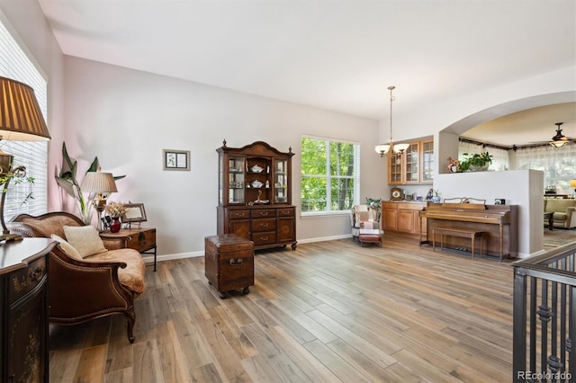 1488 Baguette Dr, Castle Rock, CO 80108 - sitting room with light wood-style floors, a ceiling fan, arched walkways, a chandelier, and baseboards