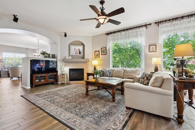 1488 Baguette Dr, Castle Rock, CO 80108 - living room with a ceiling fan, wood finished floors, a fireplace, and arched walkways
