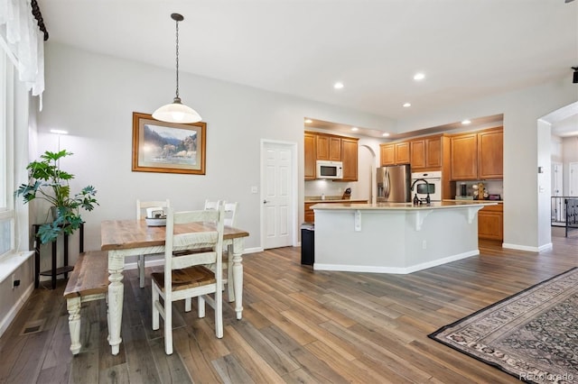 1488 Baguette Dr, Castle Rock, CO 80108 - kitchen featuring arched walkways, white appliances, wood finished floors, light countertops, and recessed lighting