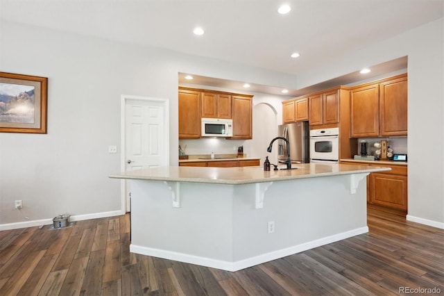 1488 Baguette Dr, Castle Rock, CO 80108 - kitchen featuring white microwave, a large island, light countertops, dark wood-style floors, and a kitchen breakfast bar