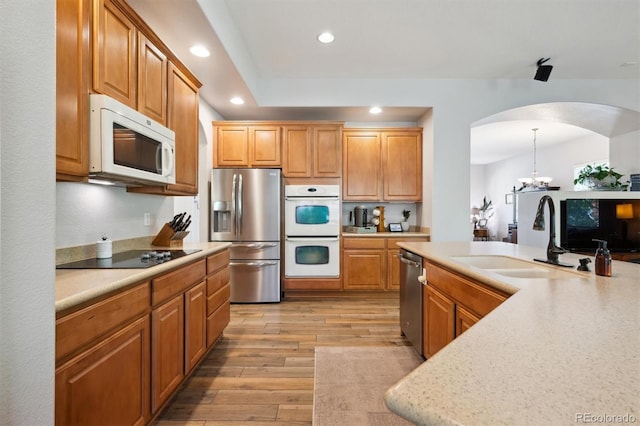 1488 Baguette Dr, Castle Rock, CO 80108 - kitchen with stainless steel appliances, a sink, arched walkways, recessed lighting, and light countertops