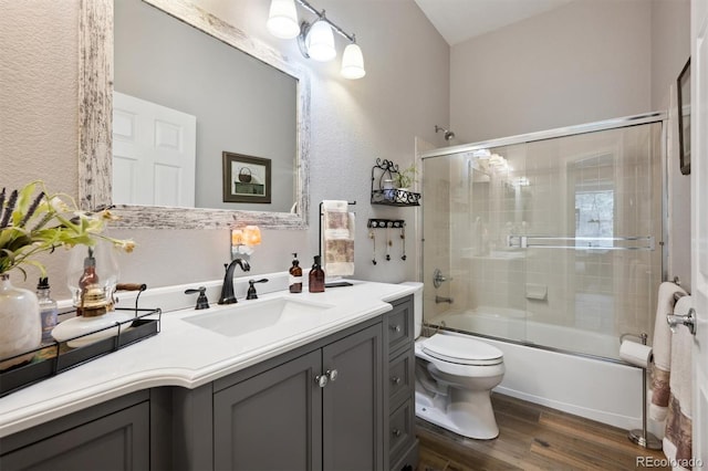1488 Baguette Dr, Castle Rock, CO 80108 - bathroom featuring wood finished floors, vanity, combined bath / shower with glass door, toilet, and a textured wall