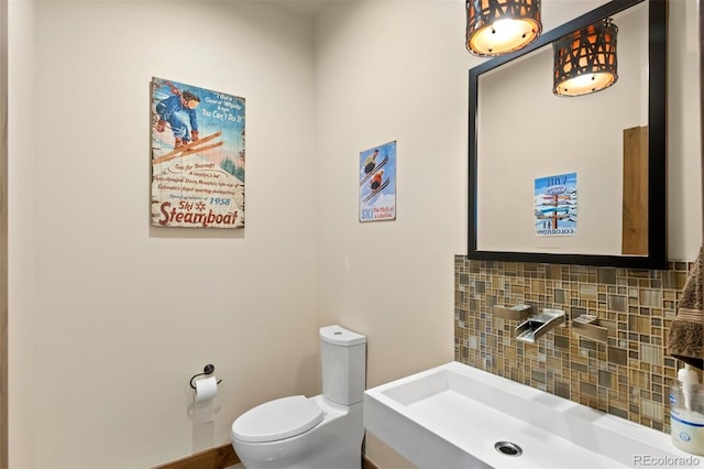 bathroom with decorative backsplash, vanity, and toilet