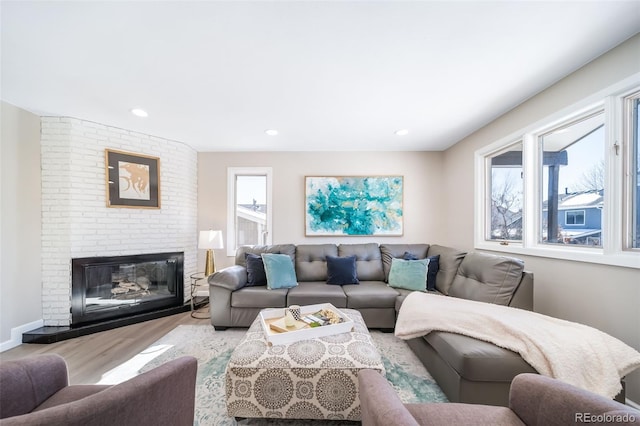 living room with light hardwood / wood-style floors and a brick fireplace