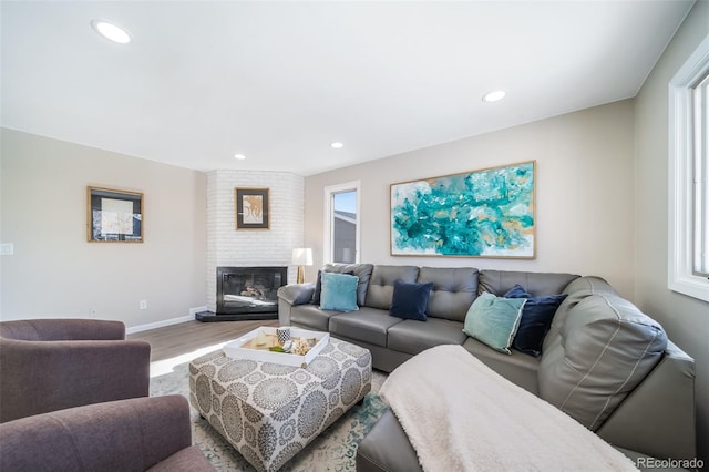 living room with hardwood / wood-style flooring and a brick fireplace