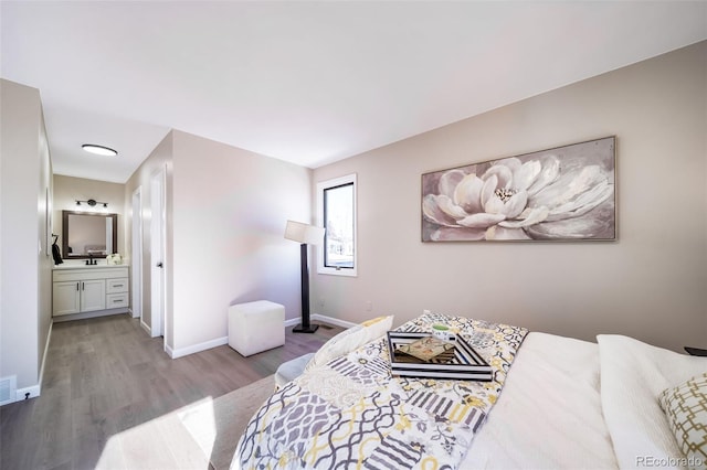 bedroom with ensuite bath and wood-type flooring