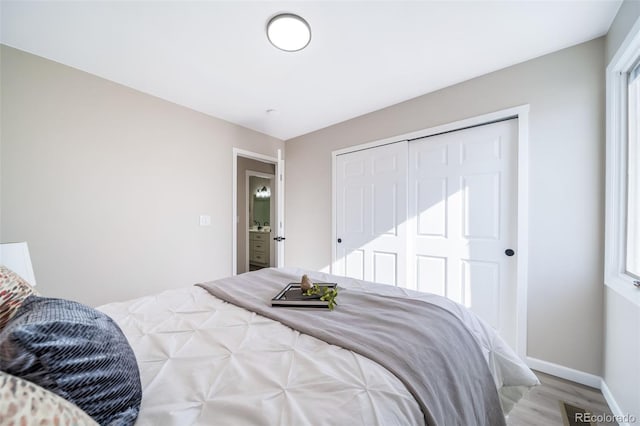 bedroom with light hardwood / wood-style floors and a closet