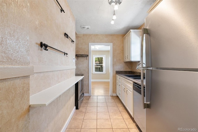 924 E Saint Vrain St, Colorado Springs, CO 80903 - kitchen with stainless steel appliances, a sink, light tile patterned floors, rail lighting, and white cabinetry