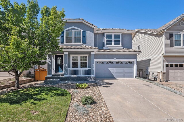1963 Hogan Ct, Castle Rock, CO 80109 - traditional-style home featuring driveway, a garage, stucco siding, a tile roof, and covered porch