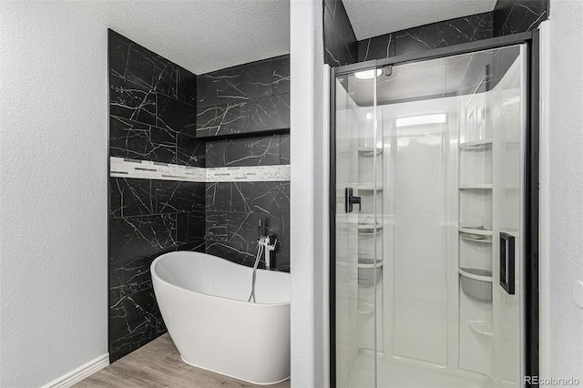 1963 Hogan Ct, Castle Rock, CO 80109 - full bath featuring a stall shower, wood finished floors, a freestanding tub, a textured ceiling, and a textured wall