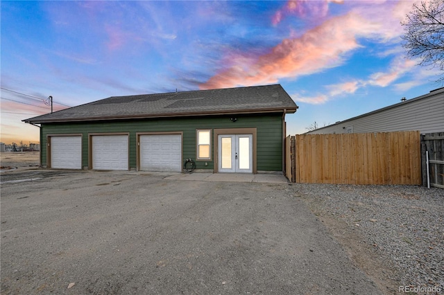 garage at dusk featuring french doors