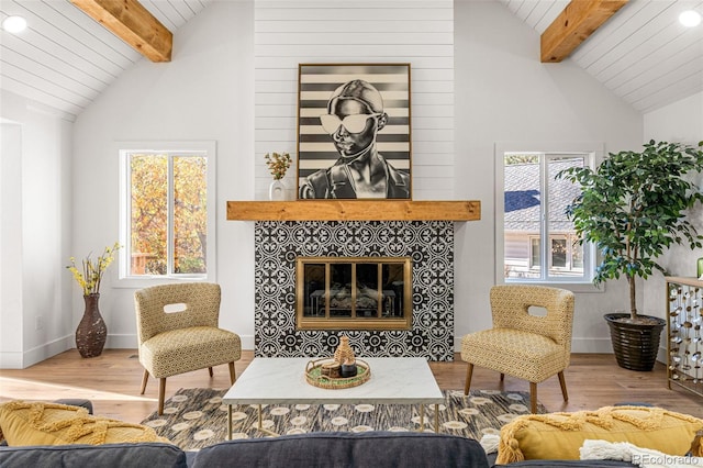 living room with hardwood / wood-style flooring, wood ceiling, vaulted ceiling with beams, and a tile fireplace