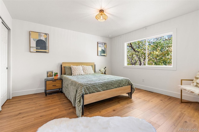 bedroom with a closet and light hardwood / wood-style flooring