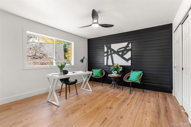 office with light wood-type flooring and ceiling fan