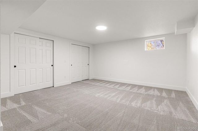 unfurnished bedroom with carpet flooring and multiple closets