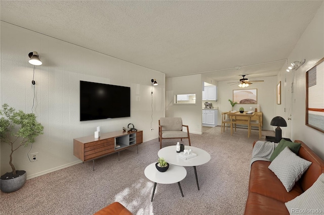 living room with a textured ceiling, wood walls, and ceiling fan