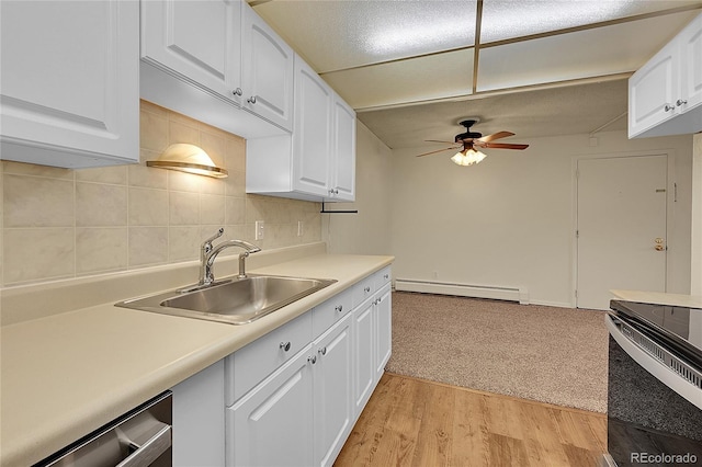 kitchen featuring white cabinetry, sink, stainless steel dishwasher, and baseboard heating