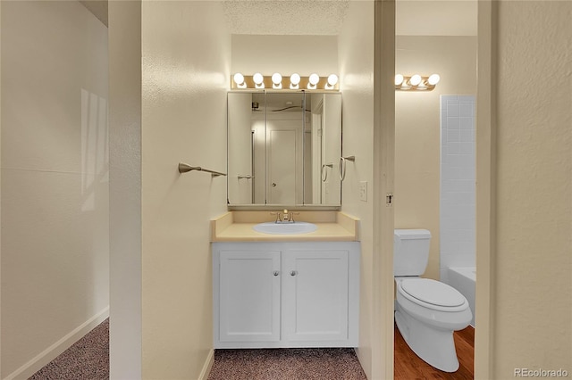 bathroom with vanity, a textured ceiling, and toilet