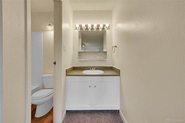 bathroom featuring vanity, a textured ceiling, and toilet