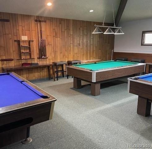 rec room featuring wooden walls, billiards, beam ceiling, and carpet