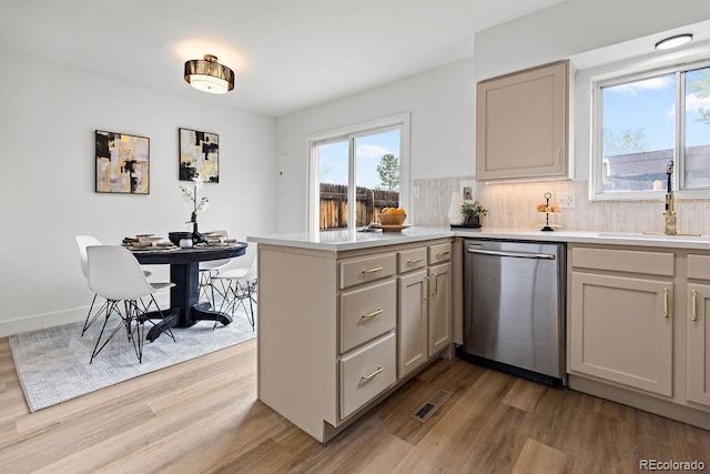 5667 S Lowell Blvd, Littleton, CO 80123 - kitchen with stainless steel dishwasher, a sink, wood finished floors, a peninsula, and healthy amount of natural light