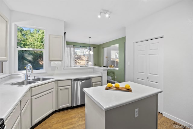 1464 Spotted Owl Way, Highlands Ranch, CO 80129 - kitchen featuring stainless steel dishwasher, light wood-style flooring, light countertops, hanging light fixtures, and a center island