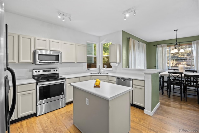 1464 Spotted Owl Way, Highlands Ranch, CO 80129 - kitchen featuring appliances with stainless steel finishes, a chandelier, healthy amount of natural light, and a kitchen island
