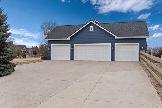 view of front of home with concrete driveway, a shingled roof, and fence