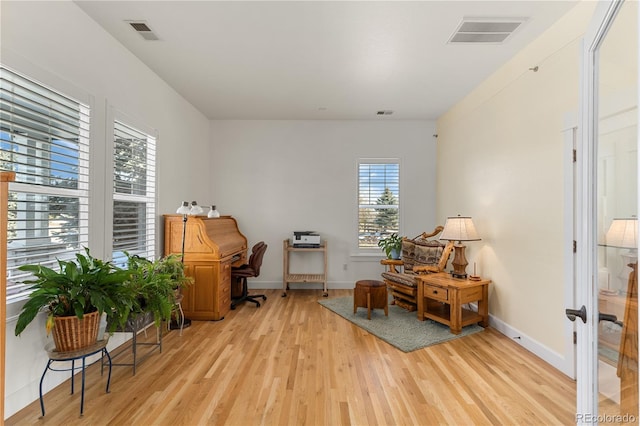 office featuring light wood-style floors, baseboards, and visible vents