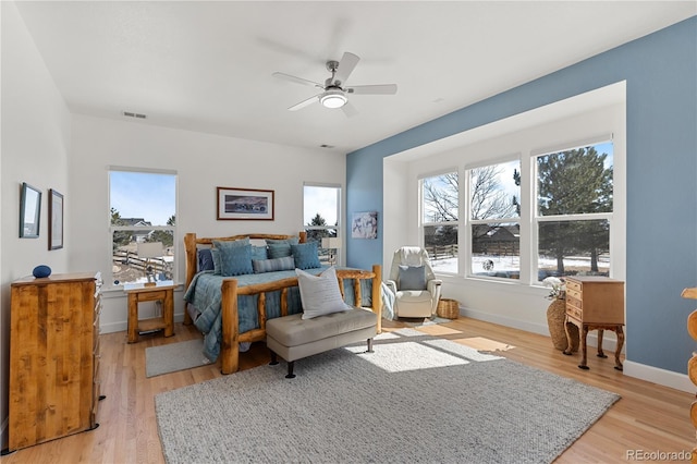 bedroom featuring light wood-type flooring, baseboards, visible vents, and a ceiling fan