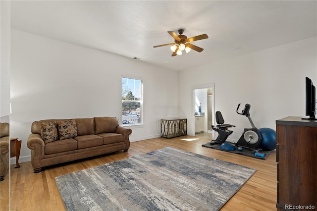 interior space featuring light wood-style floors, baseboards, visible vents, and a ceiling fan