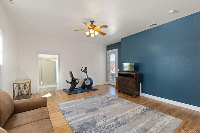 workout room with a ceiling fan, baseboards, and wood finished floors