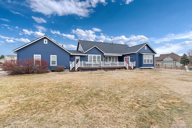 back of property featuring a lawn and a wooden deck