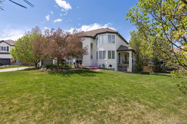 view of front facade featuring a front yard, stucco siding, and driveway